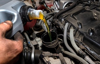 car-mechanic-pours-new-car-oil-into-the-engine-fro-2021-09-02-22-07-19-utc